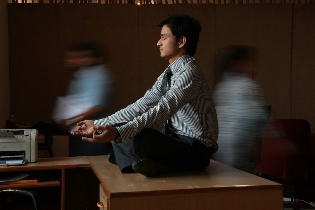 Person sitter meditativt på ett skrivbord i en kontorsmiljö